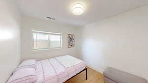 Bedroom with wood finished floors and baseboards