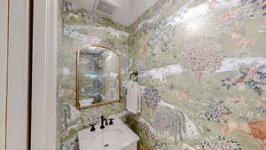 Bathroom featuring vanity and wallpapered walls