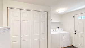Laundry area featuring washing machine and dryer and a textured ceiling