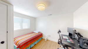 Bedroom featuring wood finished floors and baseboards