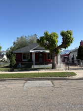 View of front of house with a fenced front yard, a gate, and a shingled roof