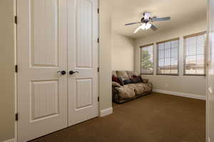 Sitting room with carpet flooring, ceiling fan, and baseboards