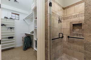 Bathroom featuring a stall shower and a walk in closet