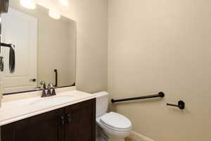 Bathroom featuring toilet, vanity, and baseboards