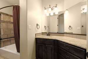 Full bath featuring shower / tub combo and vanity
