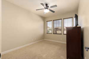 Carpeted empty room with baseboards and ceiling fan