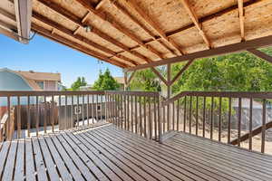 Wooden terrace with a fenced backyard