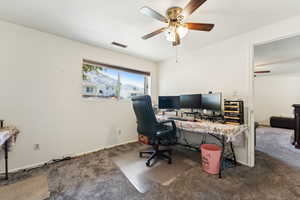 Home office with ceiling fan, carpet, and baseboards