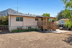 Back of house featuring a patio area, a fenced backyard, stairs, and a deck with mountain view