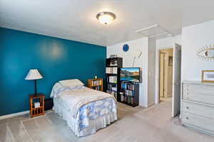 Bedroom featuring carpet floors, a textured ceiling, and baseboards