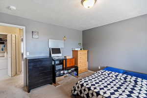Bedroom featuring light carpet and a textured ceiling