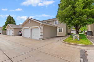 View of front of house with stucco siding, central AC, and an attached garage