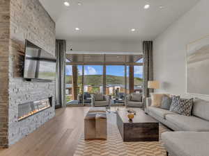 Living area featuring a fireplace, hardwood / wood-style flooring, recessed lighting, and plenty of natural light