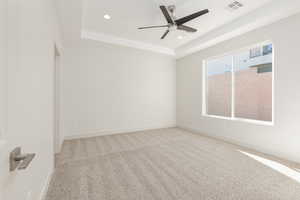 Empty room with a raised ceiling, recessed lighting, a ceiling fan, baseboards, and carpet floors