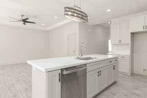 Kitchen with stainless steel dishwasher, a sink, ceiling fan, recessed lighting, and a center island with sink