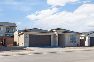 View of front of house featuring an attached garage, cooling unit, stone siding, driveway, and stucco siding