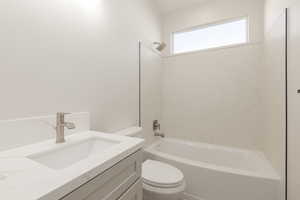 Full bathroom featuring toilet,  shower combination, and vanity