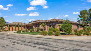 View of front of home with a garage, driveway, a tile roof, and stucco siding