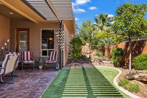 Fenced backyard featuring a patio and an area to practice putting