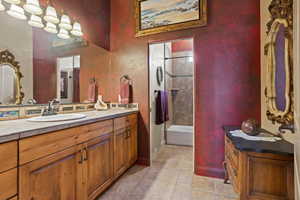 Full bathroom with vanity, tile patterned floors, shower / bath combination, and baseboards