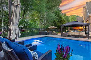 View of pool featuring an outdoor hangout area, a gazebo, a fenced backyard, and a patio area