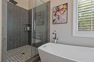 Full bath featuring a soaking tub and a stall shower