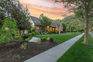 View of front of home with a yard, a chimney, and brick siding