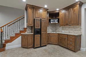 Kitchen featuring a sink, baseboards, tasteful backsplash, and recessed lighting