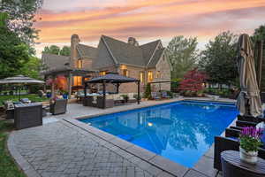 Swimming pool featuring outdoor lounge area, a gazebo, a patio area, and a diving board