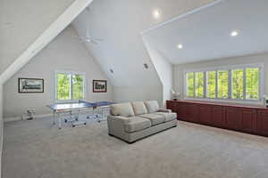 Living room with lofted ceiling, healthy amount of natural light, carpet, ceiling fan, and recessed lighting