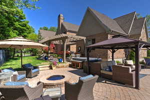 View of patio with an outdoor living space with a fire pit, a pergola, and a gazebo
