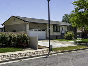 Ranch-style home featuring an attached garage, concrete driveway, and brick siding