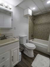 Full bathroom featuring toilet, wood finished floors, shower / bathtub combination, vanity, and recessed lighting