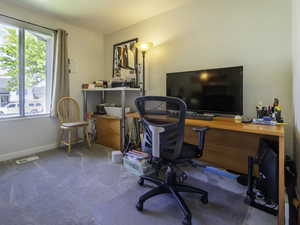 Carpeted home office featuring baseboards