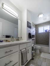 Full bathroom featuring vanity, shower / tub combination, toilet, and marble look tile flooring