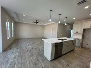 Kitchen featuring a raised ceiling, pendant lighting, wood finished floors, and recessed lighting