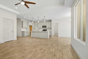 Kitchen featuring light countertops, open floor plan, recessed lighting, wood tiled floors, and decorative light fixtures
