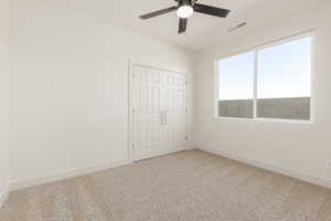 Unfurnished bedroom featuring carpet, baseboards, a closet, and ceiling fan