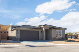 View of front facade with stone siding, an attached garage, cooling unit, concrete driveway, and stucco siding