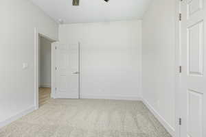 Spare room with light carpet and ceiling fan