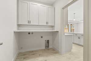 Laundry area with wood finish floors, electric dryer hookup, cabinet space, and hookup for a washing machine