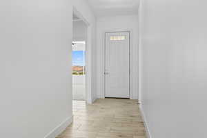 Hall with baseboards and wood tiled floors