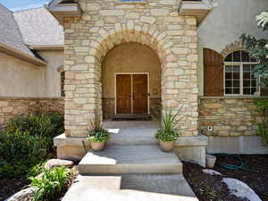 Property entrance featuring stone siding and stucco siding