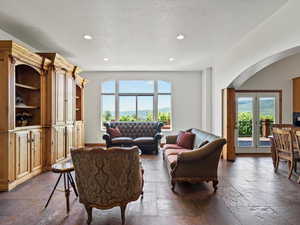 Living room with slate flooring, arched entry to kitchen, lake and mountain views