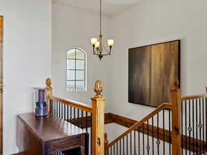 Staircase with a chandelier to lower level