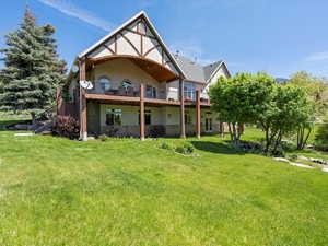 Back of property featuring a stream, and mature landscaping