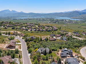 Aerial perspective of home location with wooded area, mature landscape, and protected lake views