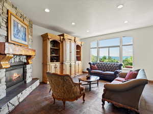 Living area featuring slate floors, stone fireplace, lake and mountain views