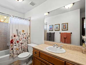 Full bath with toilet, vanity, and shower / bath combo