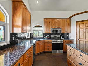 Kitchen with stone surfaces, vaulted ceiling, pantry, island, lake views
